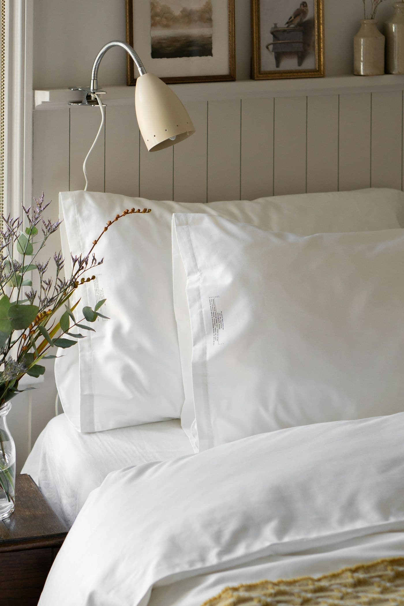 Chambre préparée pour l’arrivée de voyageurs, linge blanc et volets entrouverts
