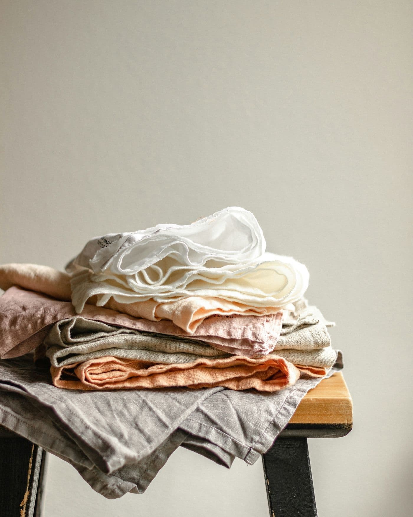 Pile de linge de maison en lin, plié sur une table en bois