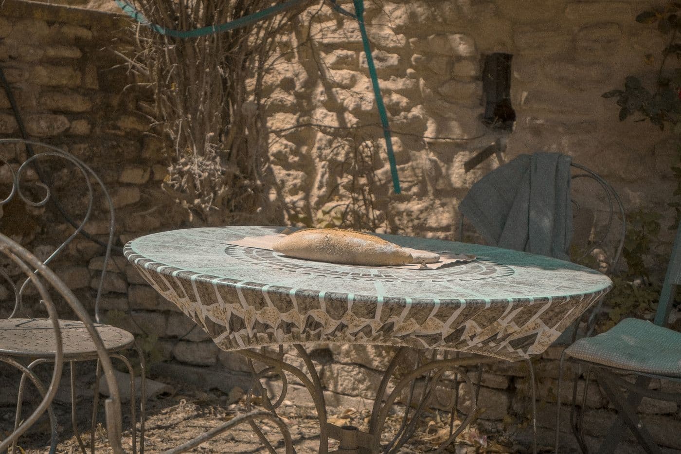 Table en pierre à l’ombre d’un arbre, dans le jardin d’une maison de vacances